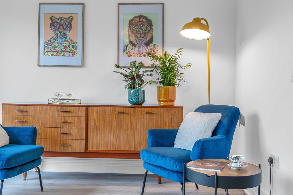 Living room with two blue chairs, a yellow standing lamp new home for sale in Kirkcaldy