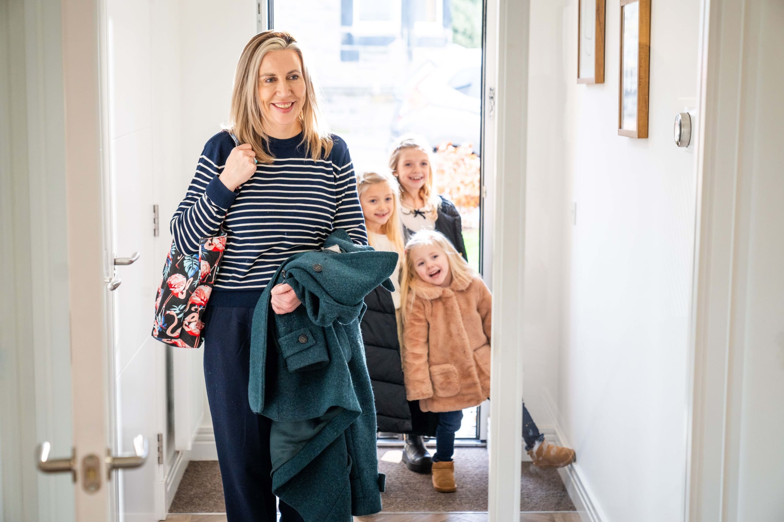 Lady and three girls walking into a new build home in March Street, Peebles