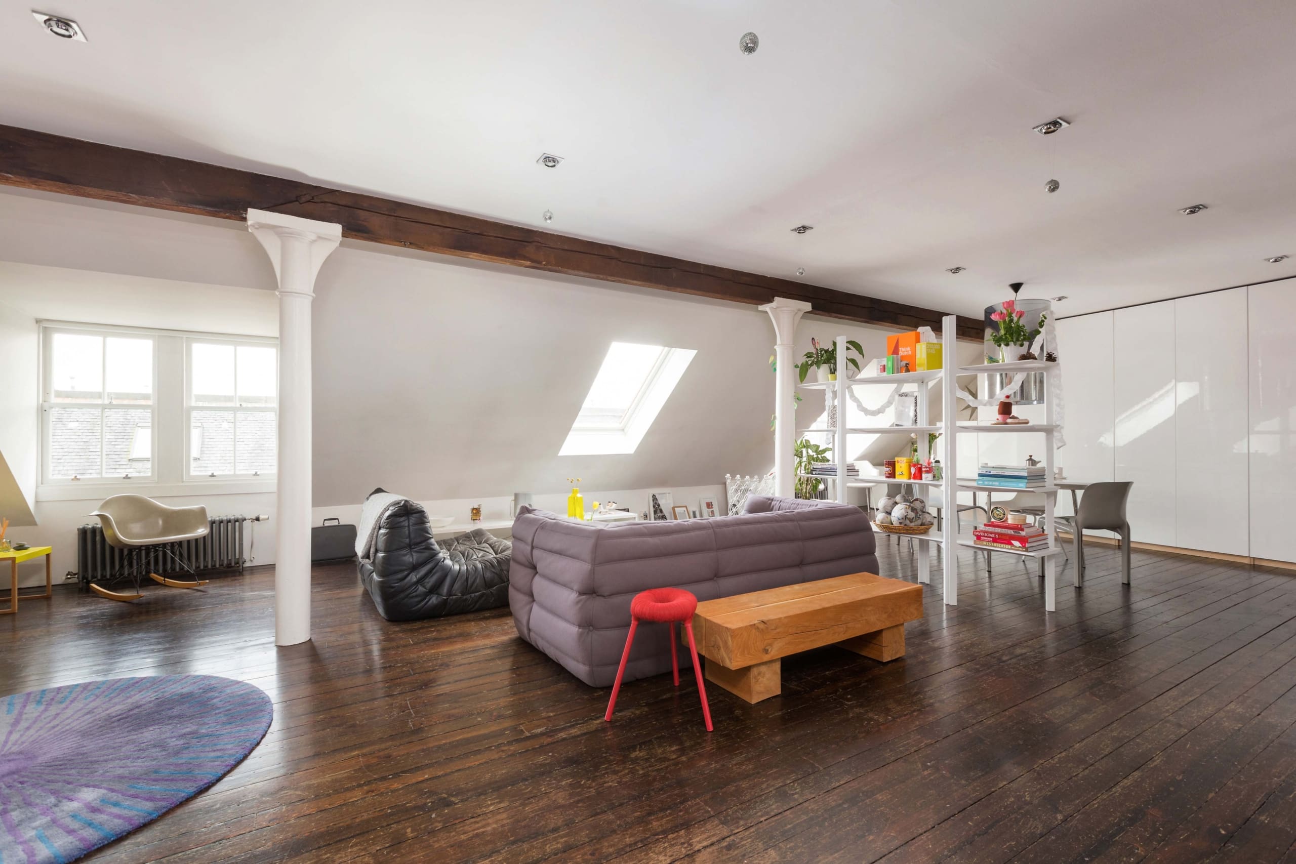 Spacious and bright loft conversion apartment in Edinburgh for sale. Living room with dark wooden floors and colourful decor