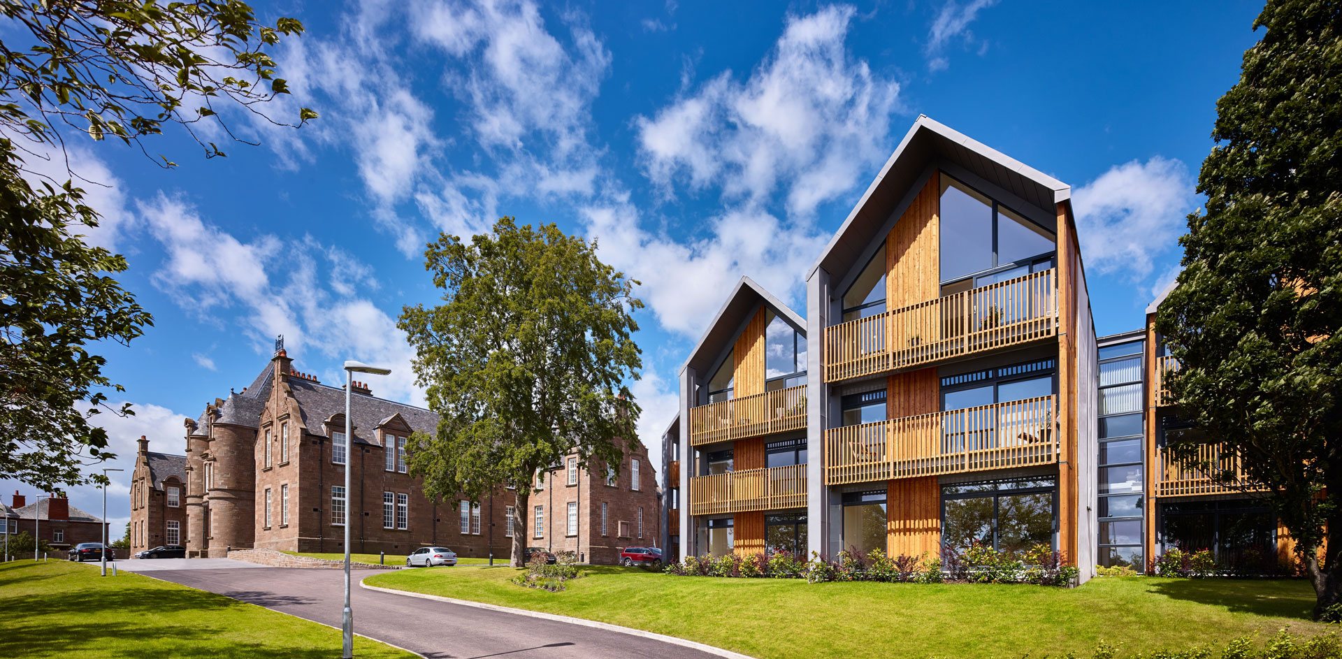 New build homes and homes in a renovated building at Parkview, Dundee. Wooden facades and floor to ceiling windows in the new build homes over three storeys.