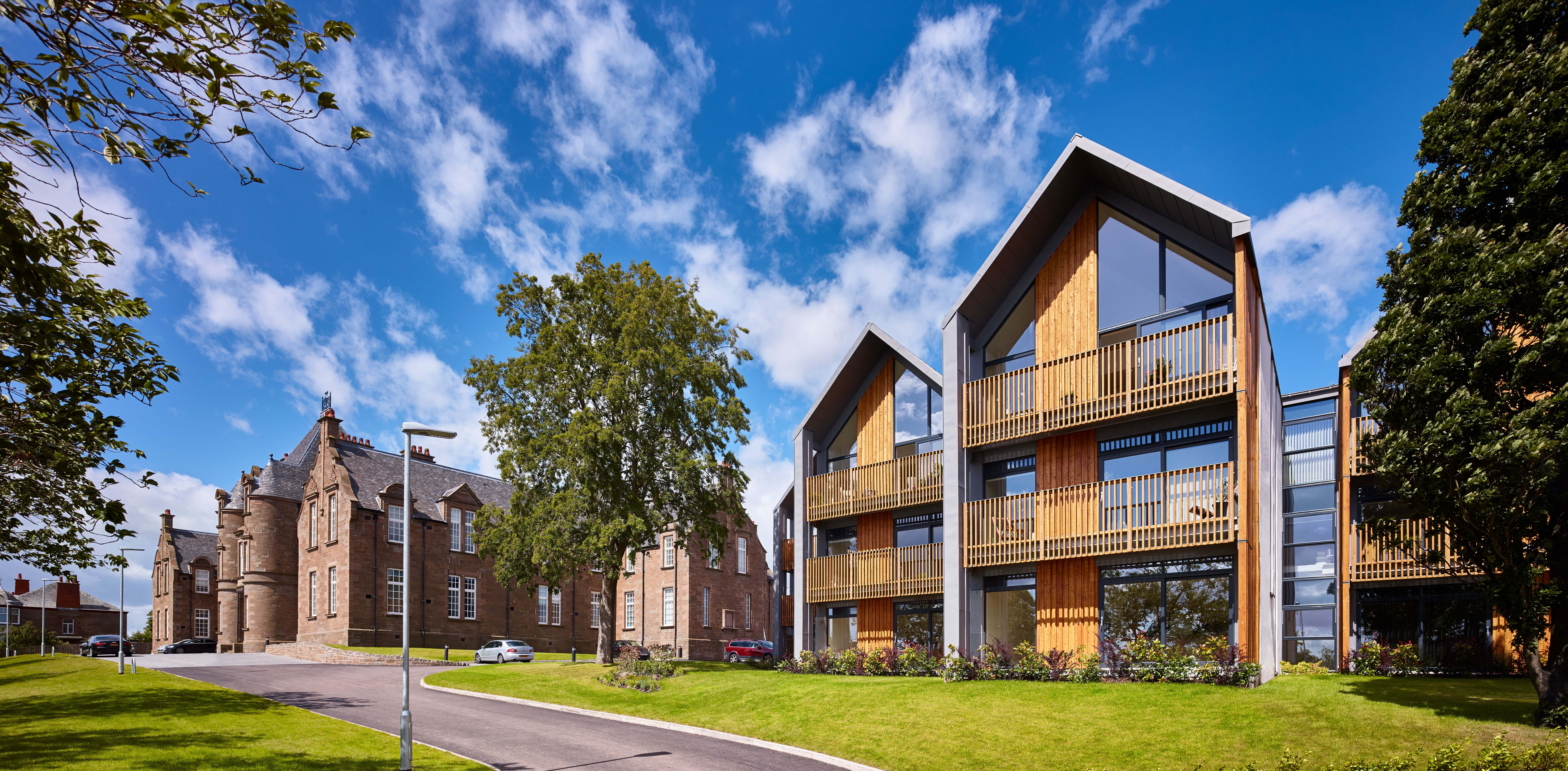 New build homes and homes in a renovated building at Parkview, Dundee. Wooden facades and floor to ceiling windows in the new build homes over three storeys.