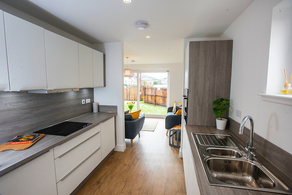 Fife, Kirkcaldy, Viewforth, New Build Homes.Modern kitchen with white units and chrome sink/tap. Kitchen leads into bright livingroom with patio doors into garden.