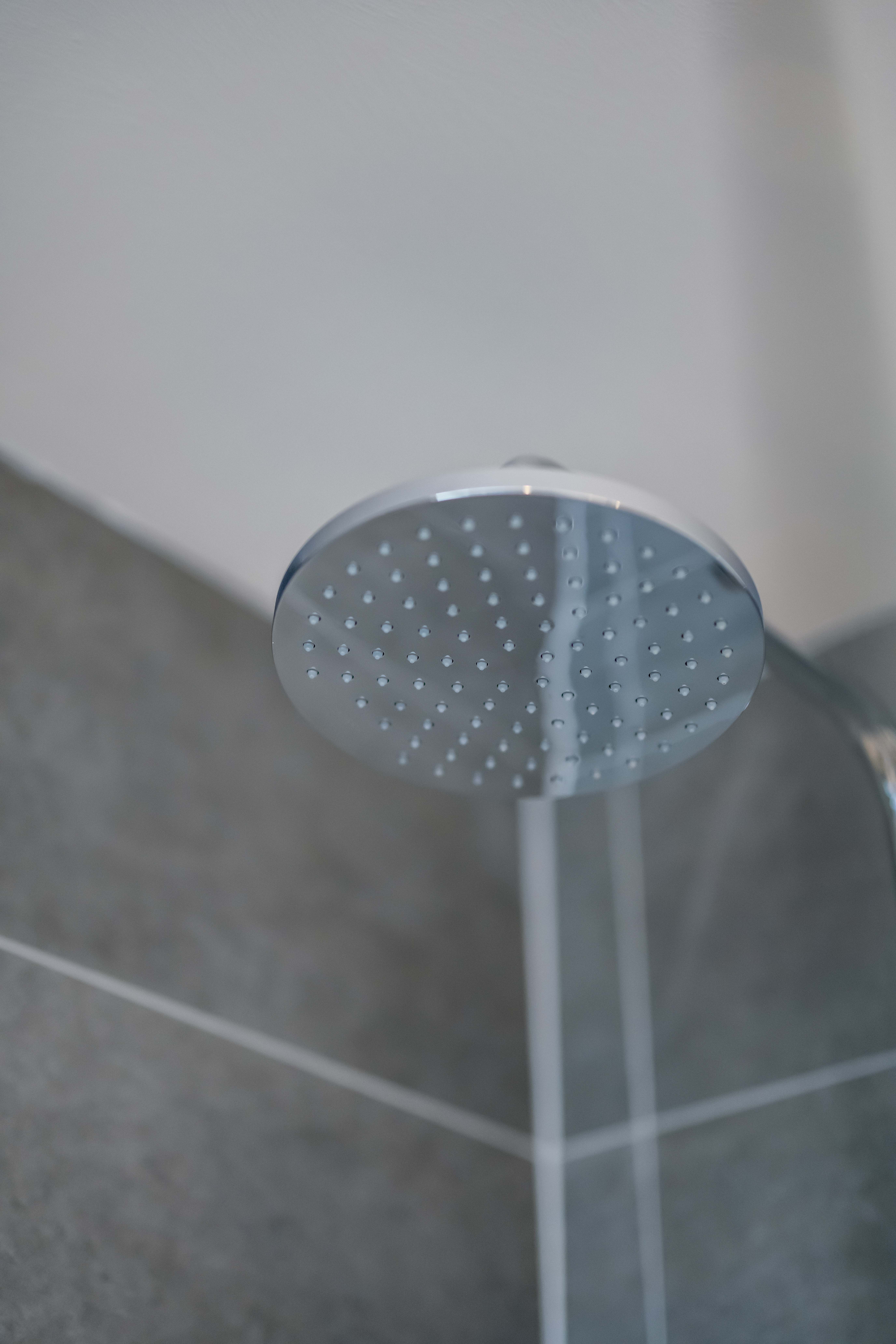 Chrome rainshower with grey tiles to background in a new home for sale in Peebles