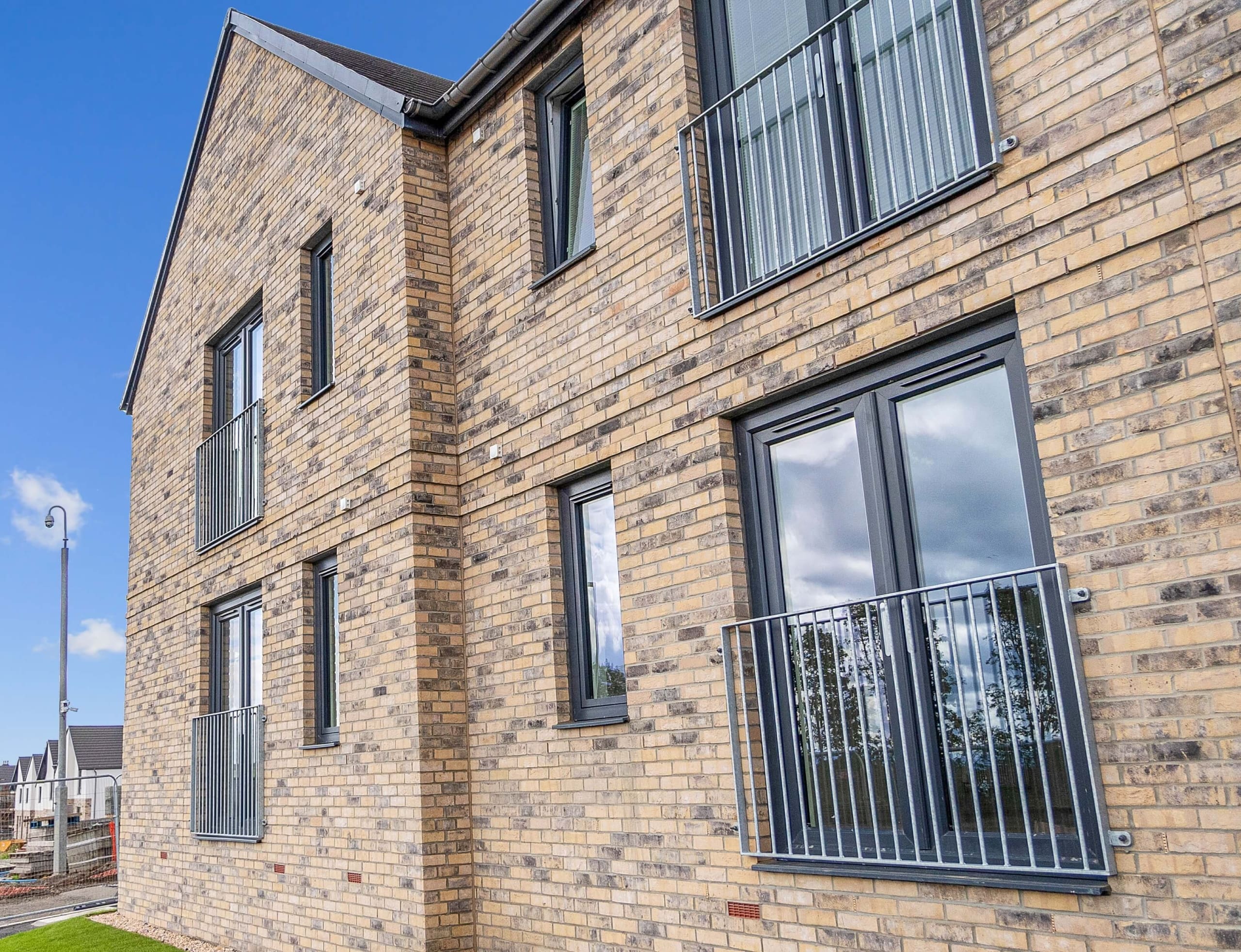 Exterior of flats in a new build development in Kirkcaldy. Featuring brick facades and juliette balconies.
