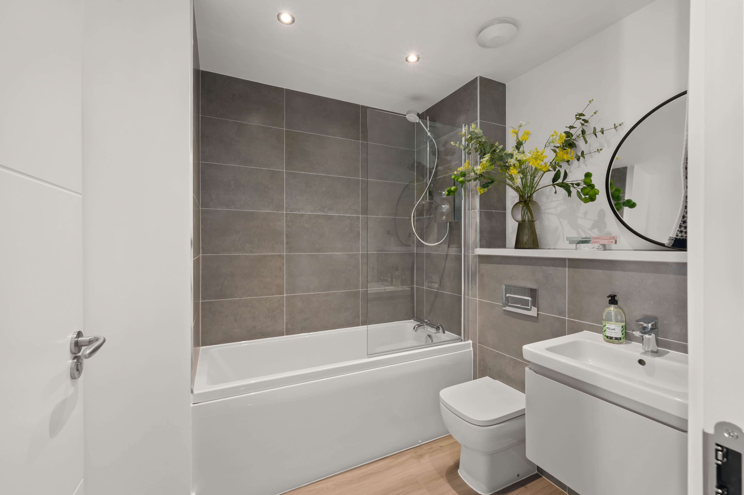 Family bathroom in new build home, Fife. Grey tiling and white sanitaryware with chrome fittings