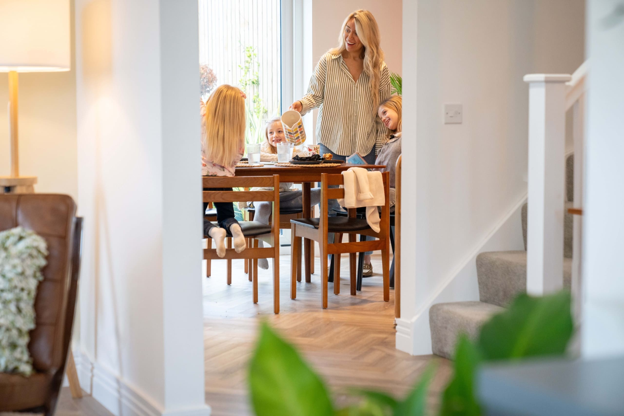 Lady pouring drinks to children in dining room in open plan living/dining/kitchen of new build home in the Scottish Borders