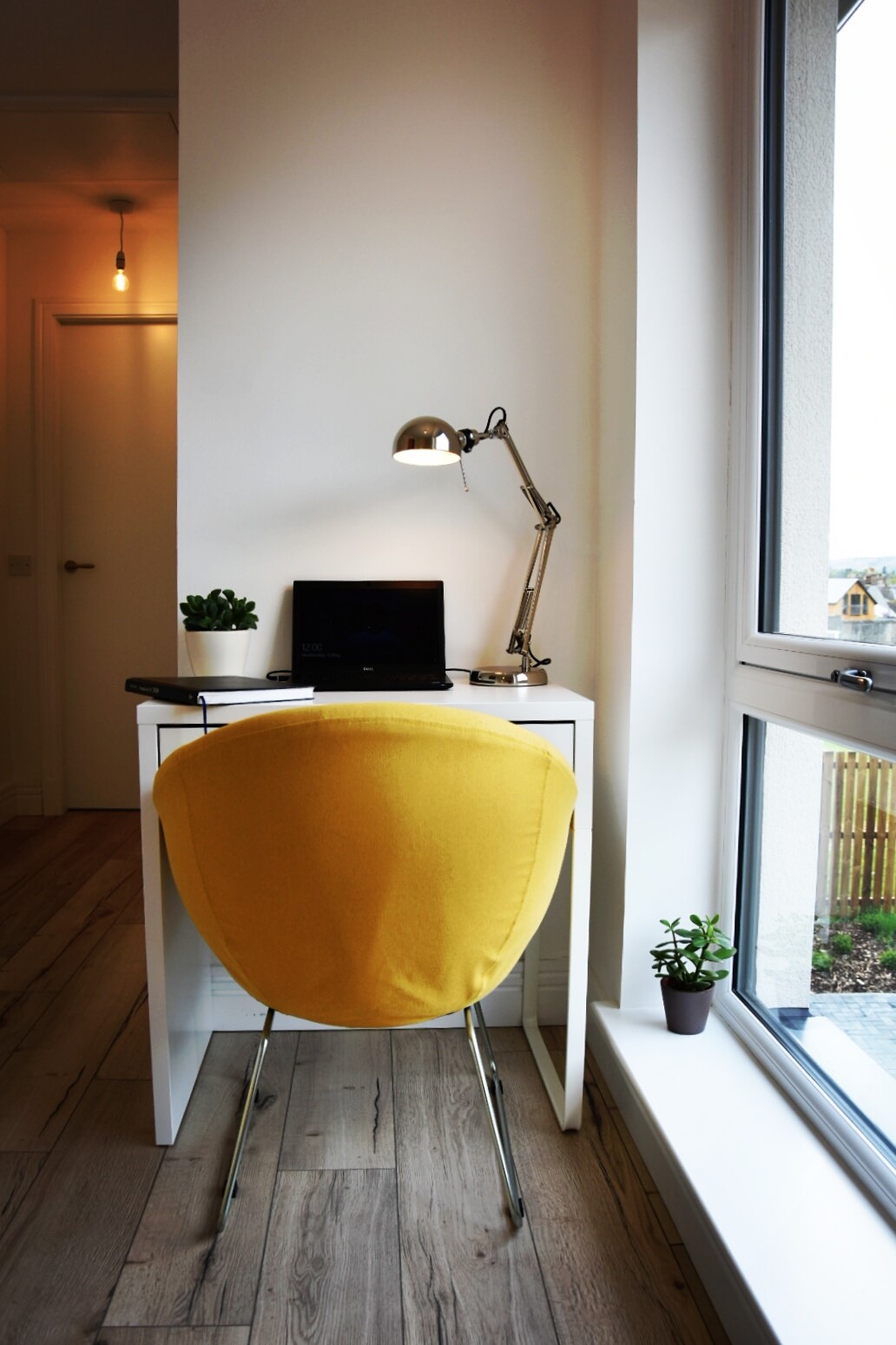 Upstairs hallway of 4 bedroom house for sale, Lauder. Work space with white desk, yellow chair and laptop, plant and light on desk