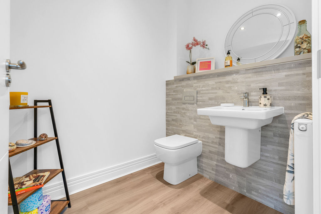 Spacious WC on the ground floor of a 3 bedroom new home for sale in the Borders. White sanitaryware, grey tiling and a wooden-effect floor
